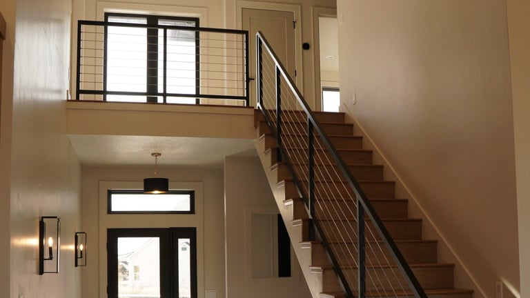 Modern entryway with wooden staircase, powder coated metal railing and loft space